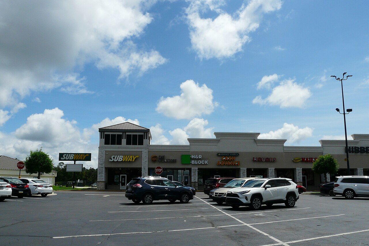 Florida commercial strip plaza with retail storefronts and parking lot